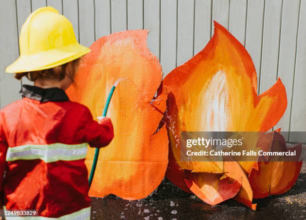 child plays firefighter role play game - uk fire rescue stock pictures, royalty-free photos & images