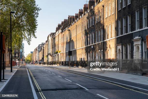 uk, london, shadows on brick buidings in empty street - urban road stock pictures, royalty-free photos & images