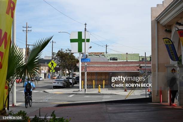 Sign with a green cross and a security camera is seen outside an unlicensed cannabis dispensary, which was closed after gun violence at the location...