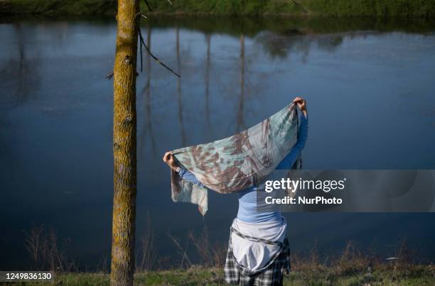 An Iranian woman adjusts her headscarf while standing next to a lake near the city of Langarud in Gilan province 354Km northwestern Tehran, during...