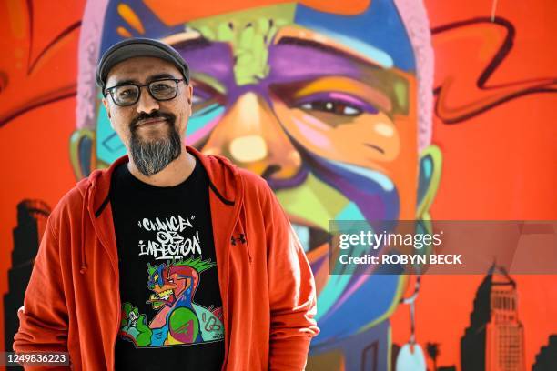 Mexican-American mural and graffiti artist Man One poses in front of his work "Noni Olabisi QEPD", March 28, 2023 at the US Bank Tower grand...