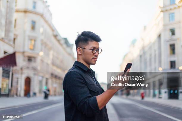 confident man exploring the city with smartphone - guy with attitude mid shot stock pictures, royalty-free photos & images