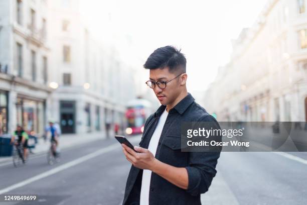 confident man exploring the city with smartphone - finance and economy stock pictures, royalty-free photos & images