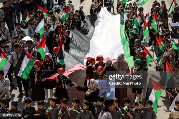 Palestinian girls hold a national flag as they mark the 47th anniversary of Land Day, on March 29, 2023 in Gaza City. - Land Day commemorates the...