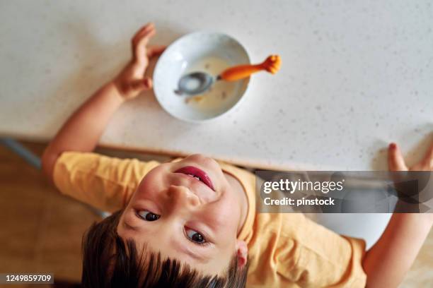 niño lindo de 4-5 años de edad comiendo escamas de maíz con leche para el desayuno. - breakfast cereal fotografías e imágenes de stock