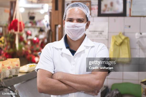 owner of a grocery store looking at camera using protective mask. - supermarket mask stock pictures, royalty-free photos & images