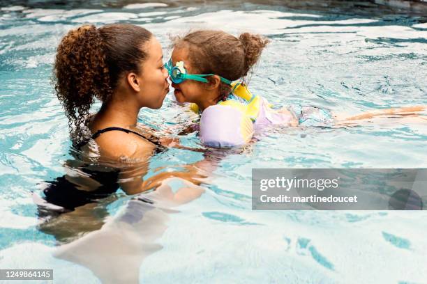 hermanas de carreras mixtas divirtiéndose en la piscina del patio trasero. - backyard pool fotografías e imágenes de stock