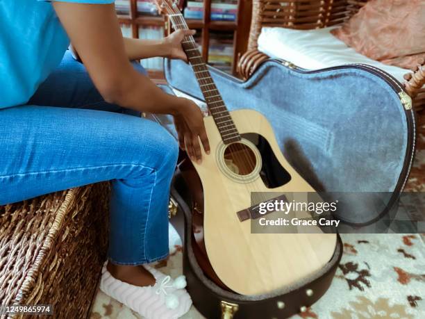 woman removes guitar from case - custodia per chitarra foto e immagini stock