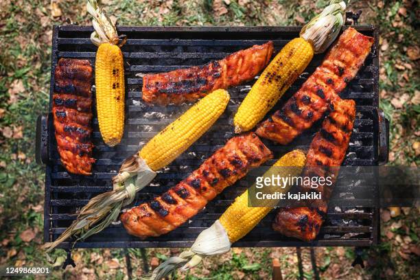 het voorbereiden van varkensribbetjes op de barbecuegrill in de binnenplaats - backyard grilling stockfoto's en -beelden