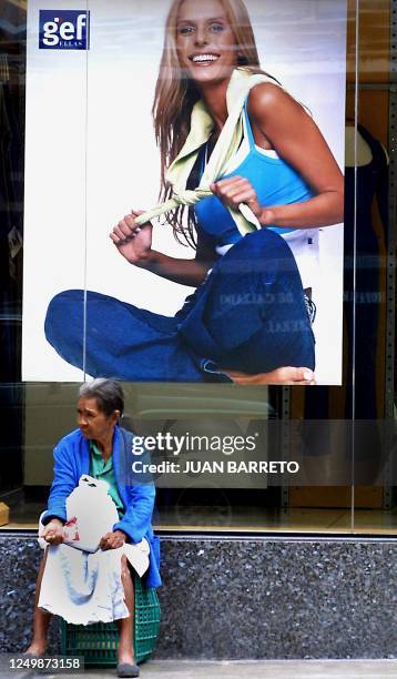 Woman asks for alms in front of a store on one of the main streets of Caracas, Venezuela, the 24 May 2001. Una mujer pide limosna frente a una tienda...