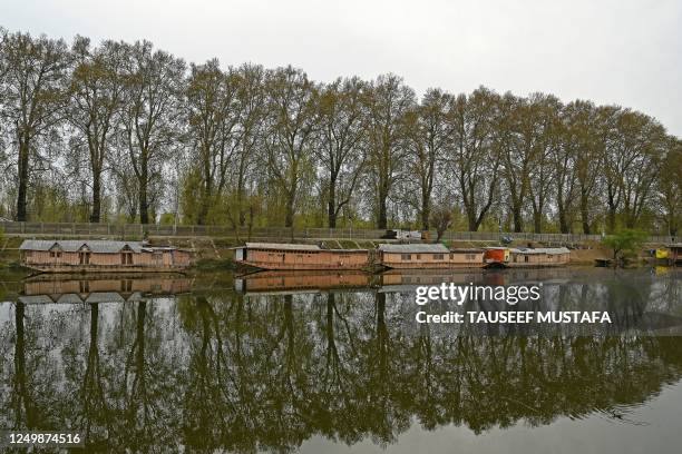 House boats are seen moored at Jehlum River in Srinagar on March 29, 2023.