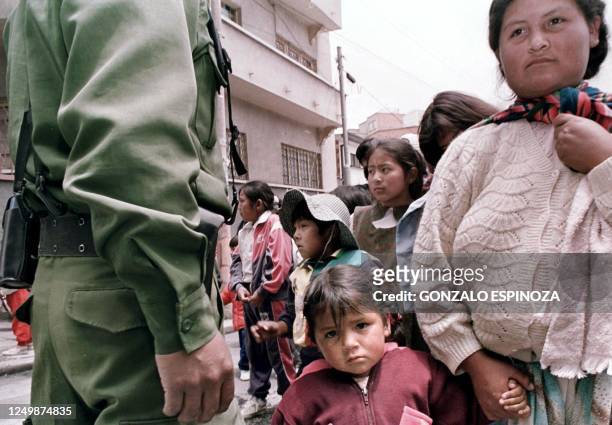 Dorita Yucra and her mother wait in line to enter a soccer stadium in La Paz to receive donated Christmas gifts for the poor 23 December, 1999....