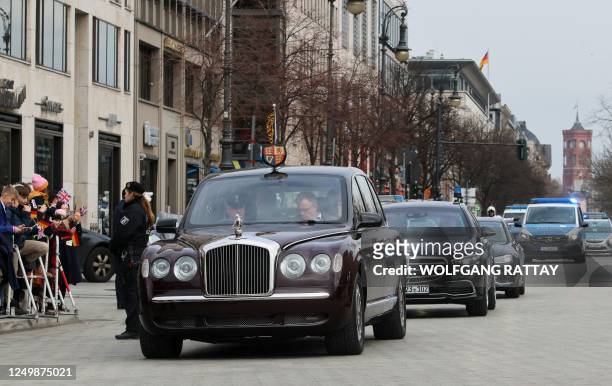 Britain's King Charles III and Britain's Camilla, Queen Consort arrive with a state limousine for a ceremonial welcome at Brandenburg Gate in Berlin,...