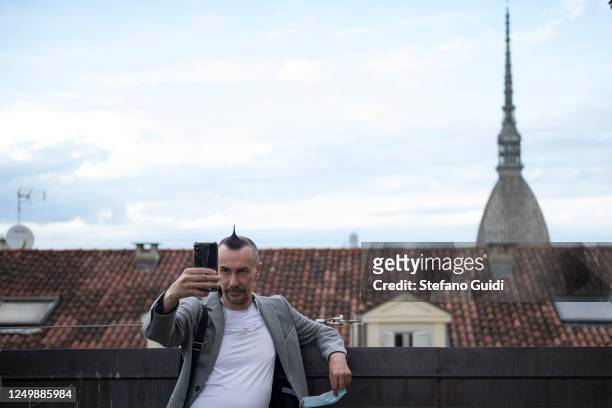 Arturo Brachetti takes a selfie with his smartphone with the background of the Mole Antonelliana of Turin during attends the launch of the new album...