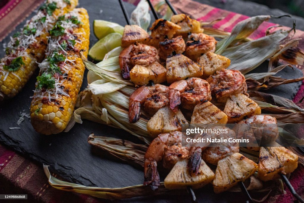 Grilled shrimp and pineapple skewers with corn