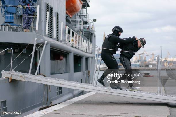 Romanian border police officer removes a detainee from the 'Alexandru Catuneanu' marine hydrographic vessel during a refugee evacuation exercise, as...