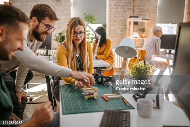 drie mensen die blokken spelen die bij bureau in evenwicht brengen - jenga stockfoto's en -beelden