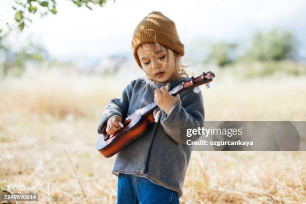 chica litlle tocando la guitarra - kids instruments fotografías e imágenes de stock