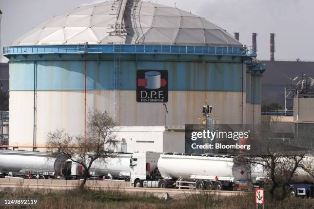 Fuel tanker trucks queue alongside a petroleum storage tank at the Depots Petroliers de Fos terminal in the industrial port area in Fos-sur-Mer,...