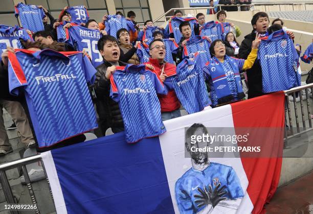 Fans of French striker Nicolas Anelka sing after his team Shanghai Shenhua played a friendly match against Hunan Xiangtao at their training ground in...