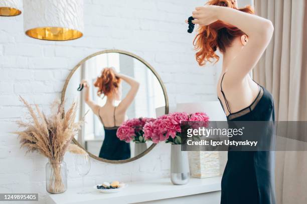 young redhead woman making ponytail - tied up ストックフォトと画像