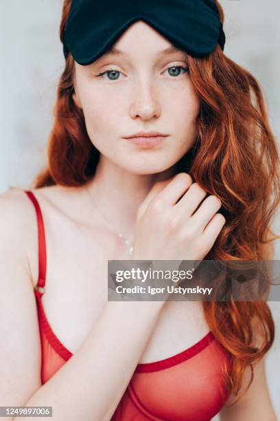 young beautiful redhead woman looking calm - eye mask foto e immagini stock