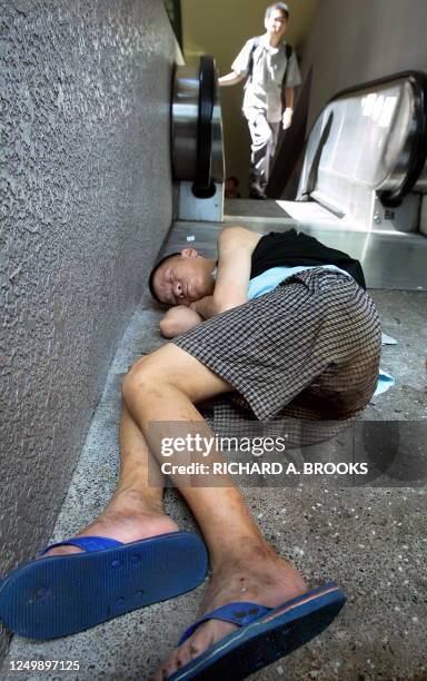 Homeless man sleeps on the pavement of a flyover in the Wan Chai district of Hong Kong, 12 July 2003. With unemployment currently at a new high of...