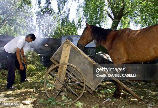 Uruguayan slum... A man who lives in slum of the peripherty of Montevideo, feeds his horse in the backyard of his house, 17 October 2002. Minutes...