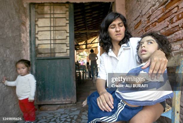 María Aguilar is seen holding her nine year old daughter Rocío who suffers from malnutrition in Corrientes, Argentina 14 August 2002. ACOMPAÑA NOTAS....