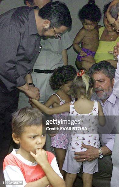 Brazilian President Luiz Inácio Lula da Silva speaks with local children in Teresina, northern Brazil, 10 January while Economy Minister Antonio...