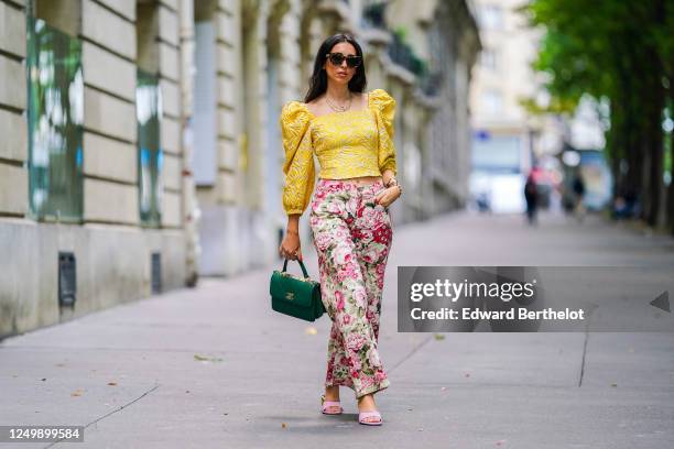 Street style photo session with Gabriella Berdugo wearing Kenzo sunglasses, a yellow ruffled top with puff sleeves and shoulder pads from Avavav,...