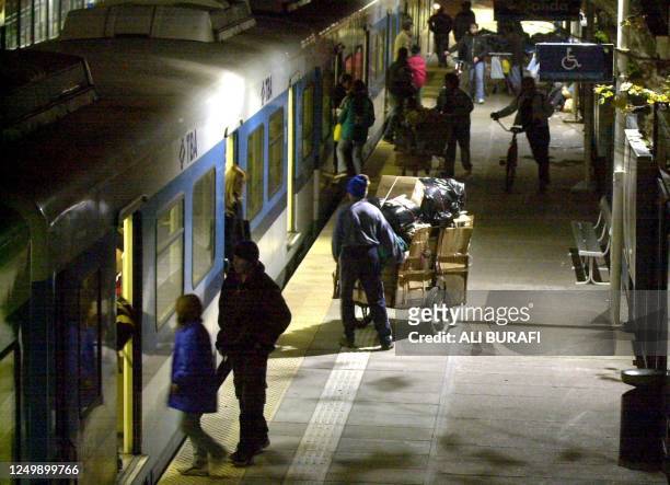 Man that collects cardboard boxes from garbage dumps for recyling , tries to board a train with his cart in Buenos Aires, 24 June 2002. Un reciclador...