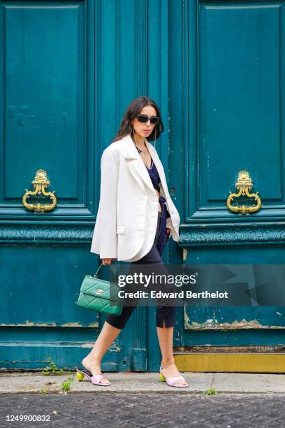 Street style photo session with Gabriella Berdugo wearing Prada sunglasses, Shaker Jewel jewelry, a white oversized blazer jacket from Salisa, a...