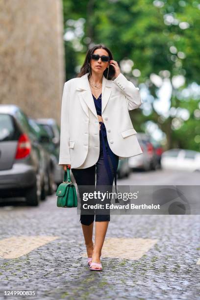 Street style photo session with Gabriella Berdugo wearing Prada sunglasses, Shaker Jewel jewelry, a white oversized blazer jacket from Salisa, a...