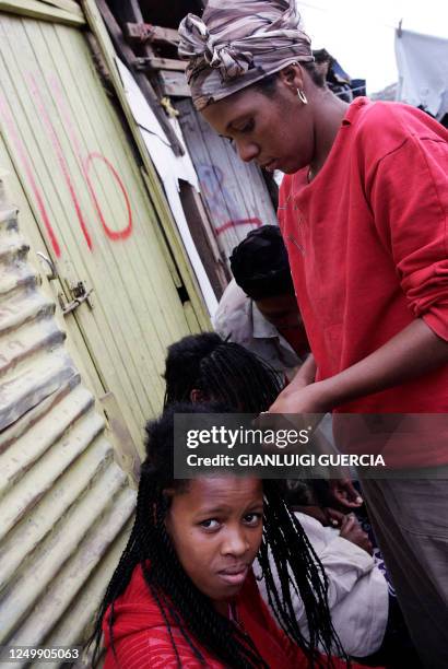 Girl gets hairdressed in one of central Durban's slums, 21 December 2005. From the slums of Durban, a new movement is giving voice to millions of...
