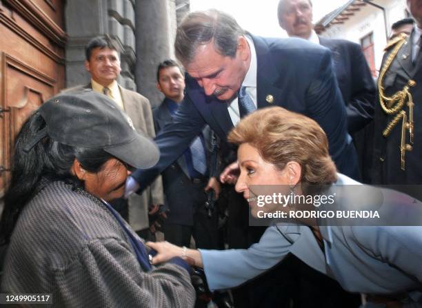 Marta Sahagun , primera dama de México y su esposo el presidente Vicente Fox saludan a una anciana en el centro historico de Quito el 22 de noviembre...