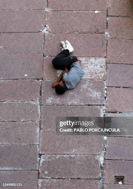 Un nino duerme en una calle del centro de Montevideo, el 02 de febrero de 2006. En 2005 mas de 2000 menores infractores fueron internados o...