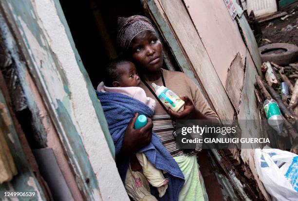Nosibusiso Tocholo holds her two-month-old baby outside her shack in one of Durban's slums, 21 December 2005. From the slums of Durban, a new...