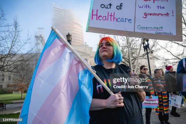 Sarah Newton stands with a trans pride flag during a rally to protest the passing of SB 150 on March 29, 2023 at the Kentucky State Capitol in...