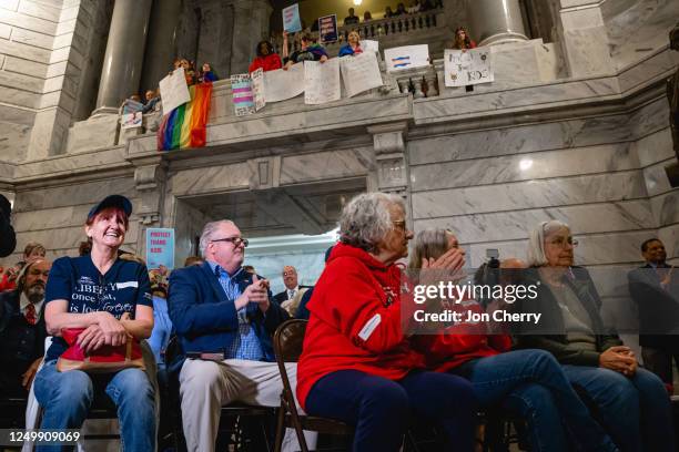 Supporters of SB 150 clap during a press conference in support of SB 150 while those opposed to the bill show signs above on March 29, 2023 at the...