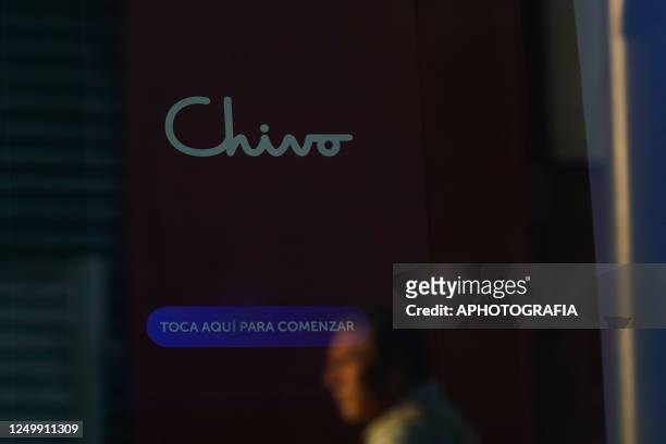 The reflection of a Salvadoran man in the door that protects an ATM of the Chivo state bitcoin wallet in different places on March 29, 2023 in San...