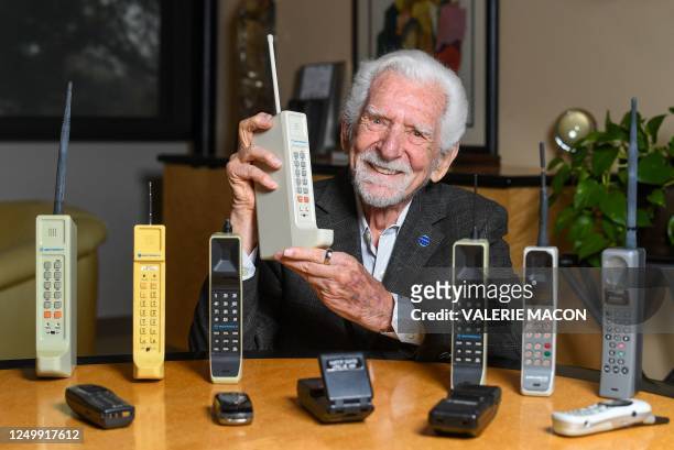 Engineer Martin Cooper holds a contemporary copy of the original cell phone he used to make the first cell phone call on April 3 in Del Mar,...
