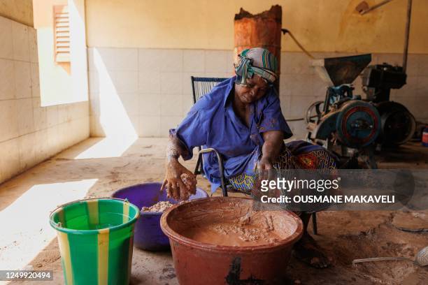 Woman mixes the shea nut paste, which will be used to make Karite butter in Siby on March 21, 2023. - Shea, a tree indigenous to Africa, and whose...