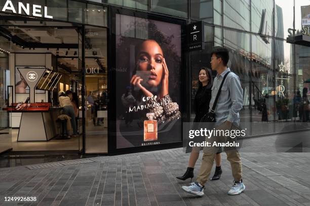 People walk past a Chanel shop in a shopping district on March 28, 2023 in Beijing, China.