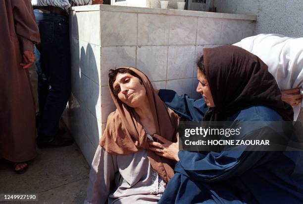 Distraught woman who has lost several close members of her family is comforted 23 September 1997 by a relative who lost her parents, at Zmirli...