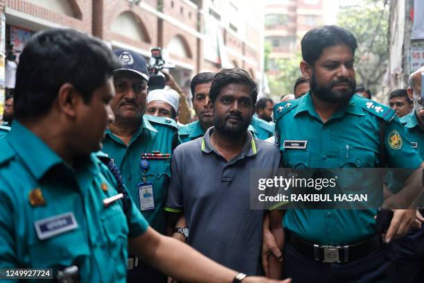 Police escort reporter Shamsuzzaman Shams , who has been arrested and charged under the Digital Security Act, to a court in Dhaka on March 30, 2023....