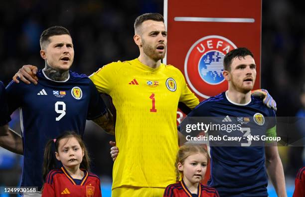 Lyndon Dykes, Angus Gunn and Andrew Robertson during the national anthems during a UEFA Euro 2024 Qualifier between Scotland and Spain at Hampden...