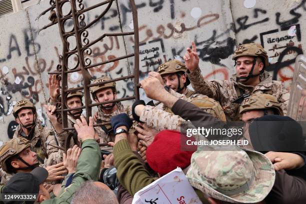 Retired servicemen clash with soldiers outside Lebanon's central bank during a demonstration demanding inflation-adjustments to their pensions, in...