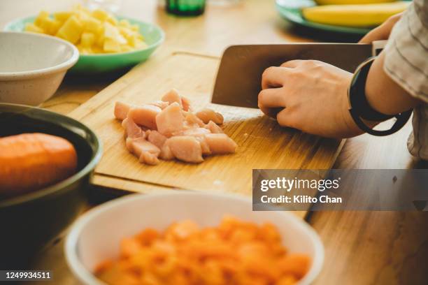 preparing japanese curry chicken-female hand chopping food - kipfilet stockfoto's en -beelden