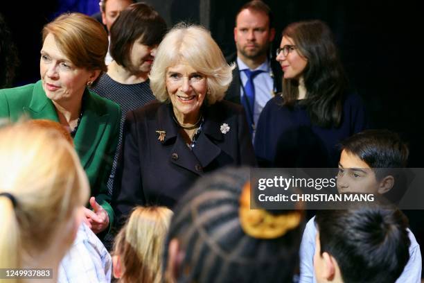 Britain's Camilla, Queen Consort , greets children next to German President's wife Elke Buedenbender at Komische Oper Berlin during their visit at...